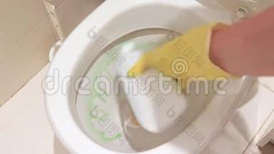 女人用黄色橡胶手套用化学药剂清洗脏马桶，卫生清洁剂
